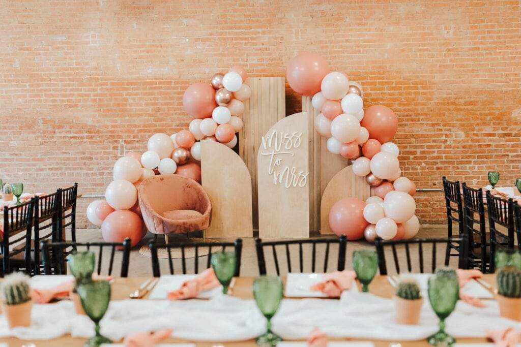 Miss to Mrs sign at a bridal event with neutral colored balloons and green accents