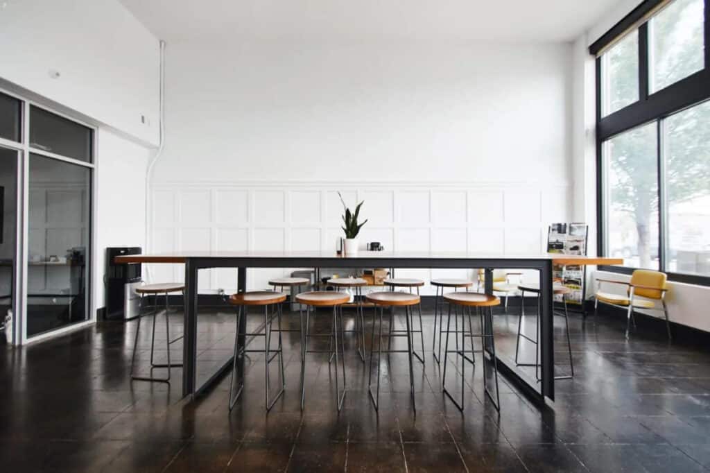 A bright contemporary sitting area with stools and a wide table