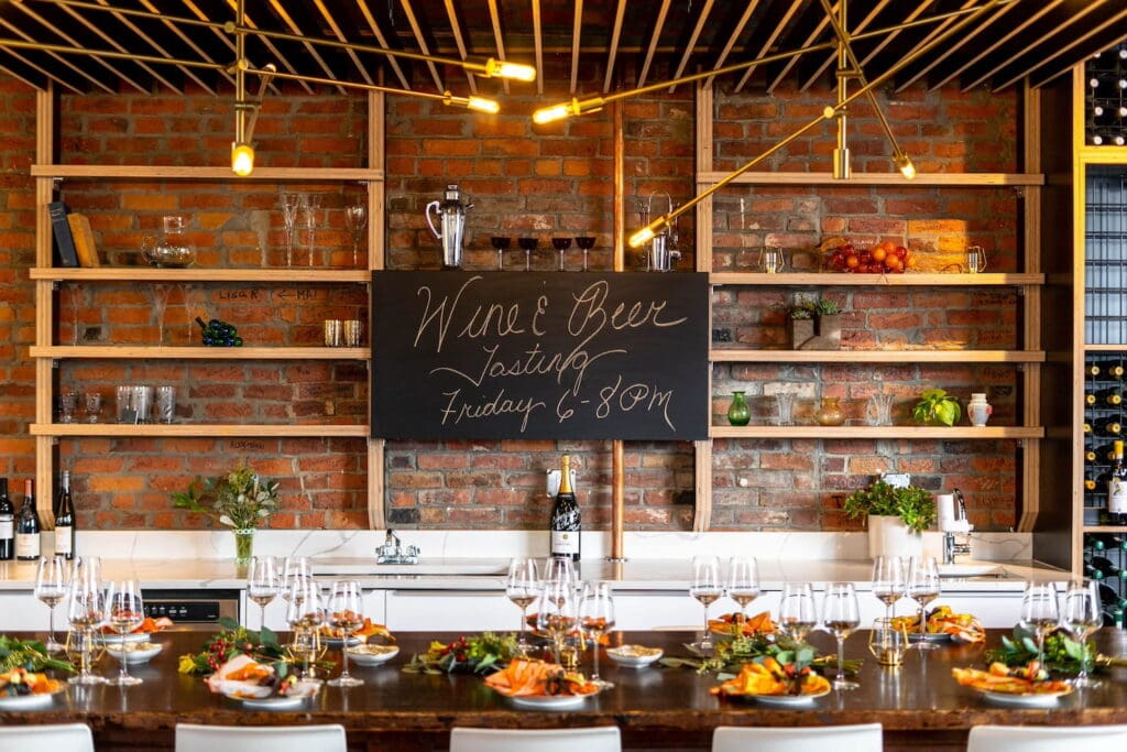 Glasses and small plates cover a tasting table at a wine and beer tasting