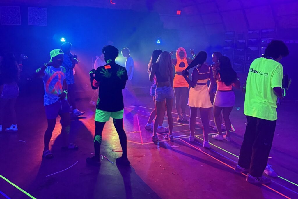 teens dancing at a neon blacklight party