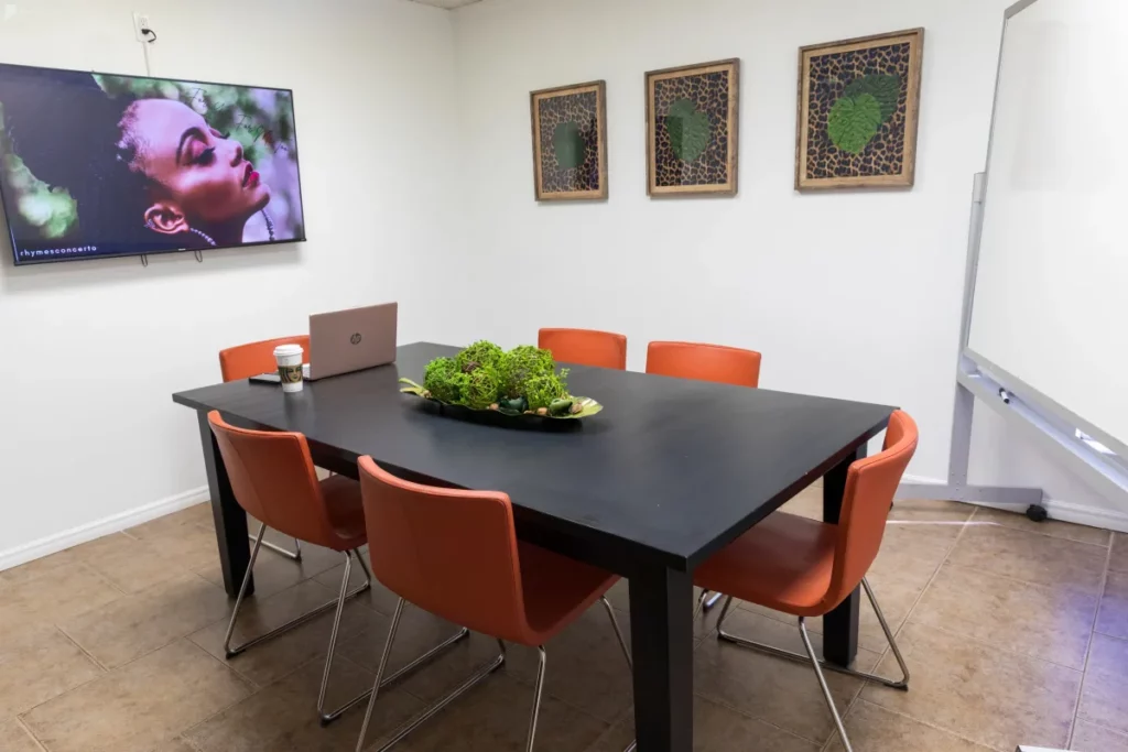 a meeting room with a screen and whiteboard