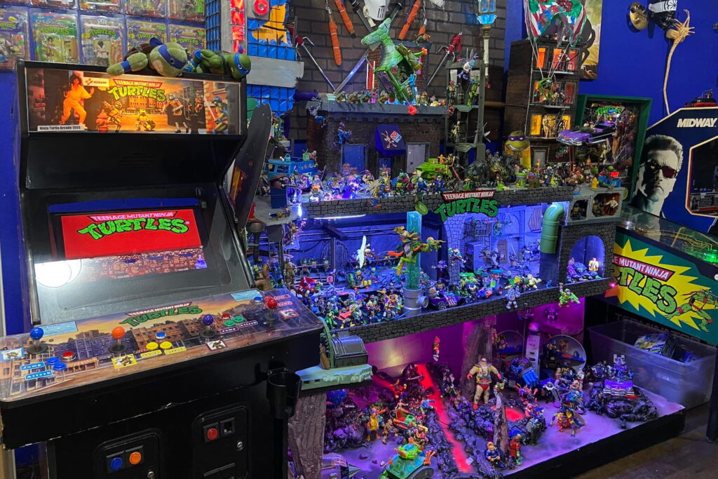 Teenage Mutant Ninja Turtles arcade games surrounded by shelves of figurines