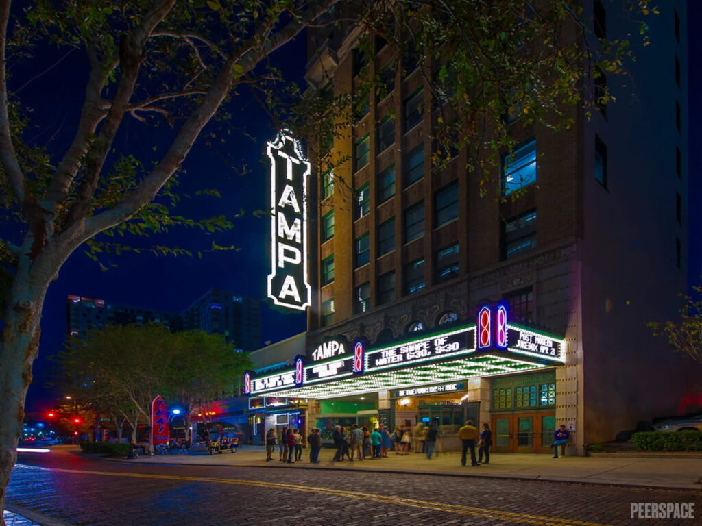 The marquis of a historic theater in Tampa shines in the night sky