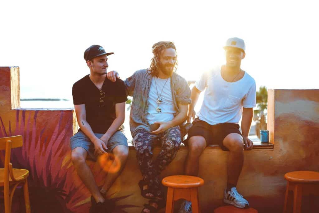 three men hanging out on a patio