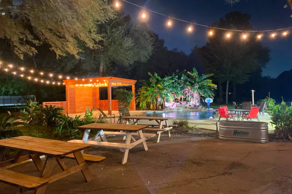 large poutdoor event space with string lights and a pool