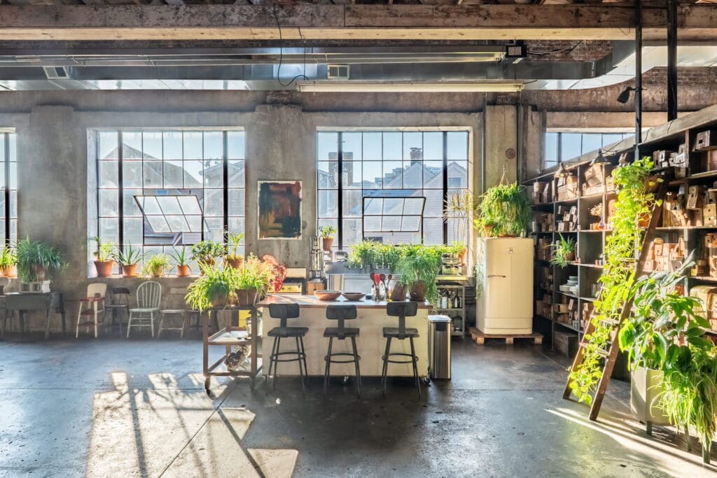Large industrial loft with huge windows and tons of greenery