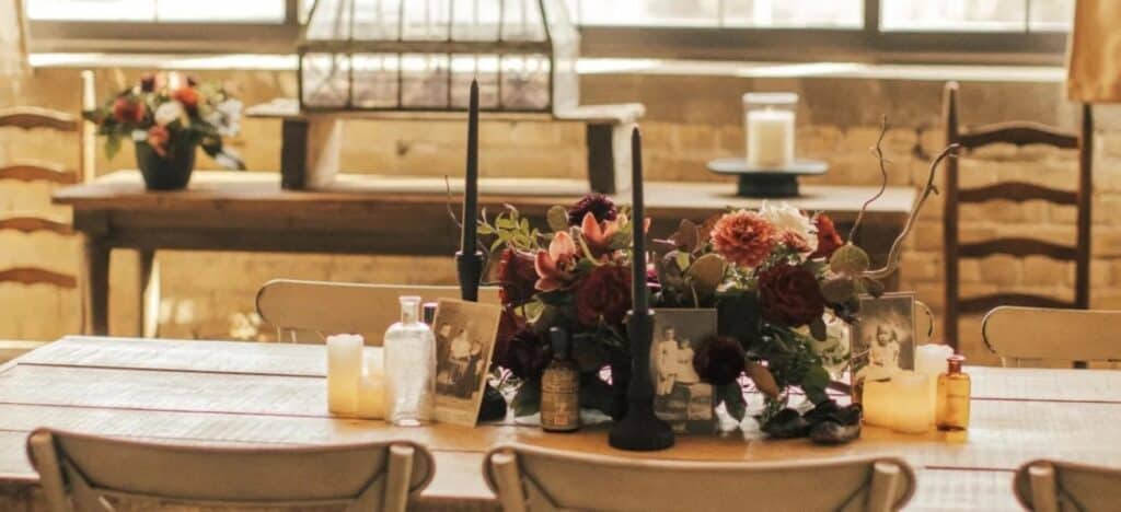 Vintage pictures sit among flowers in rustic table setting