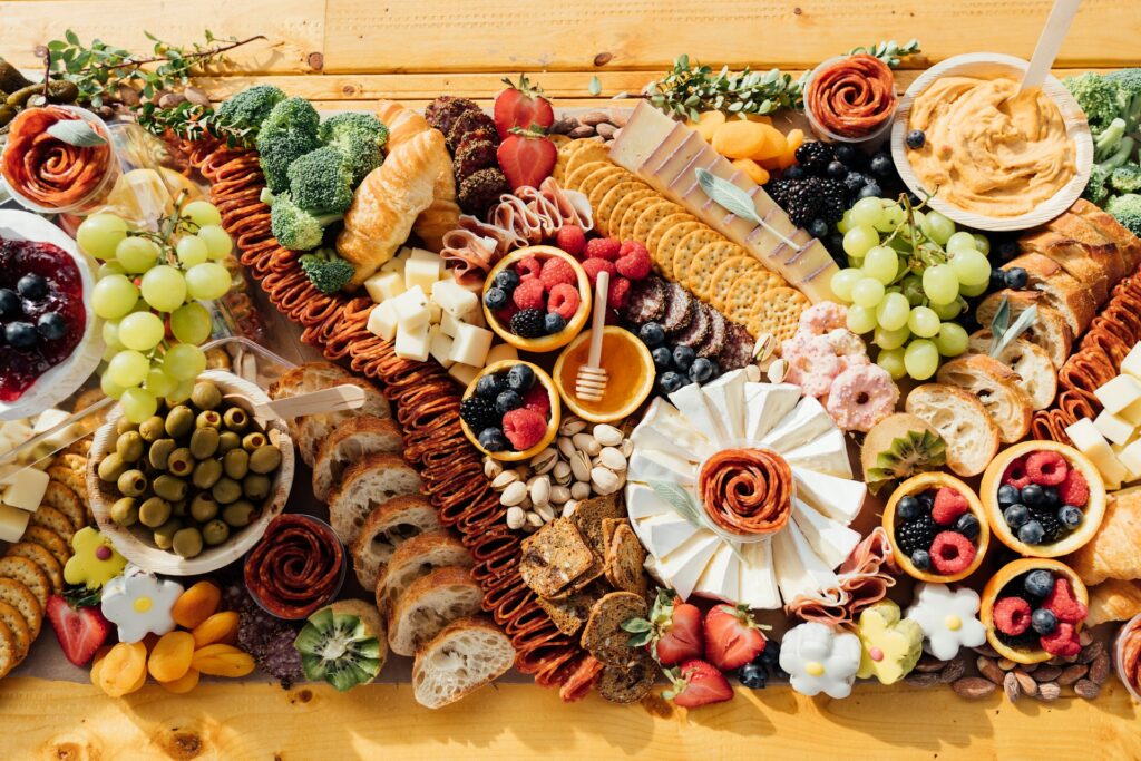 A charcuterie board with meats, cheeses, and fruits for a Galentine's theme