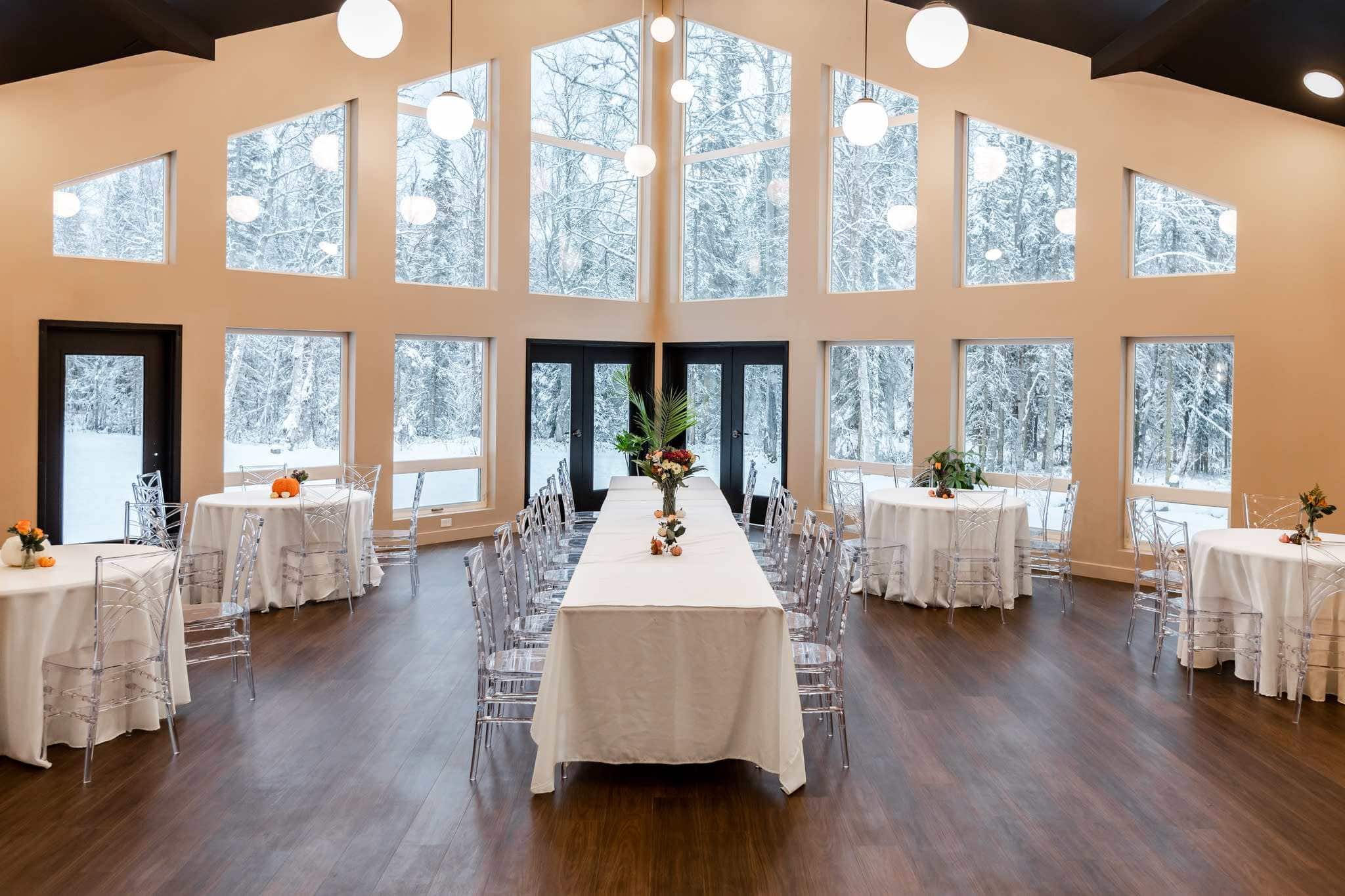 Anchorage wedding venue interior with snowy forest views and elegant tables