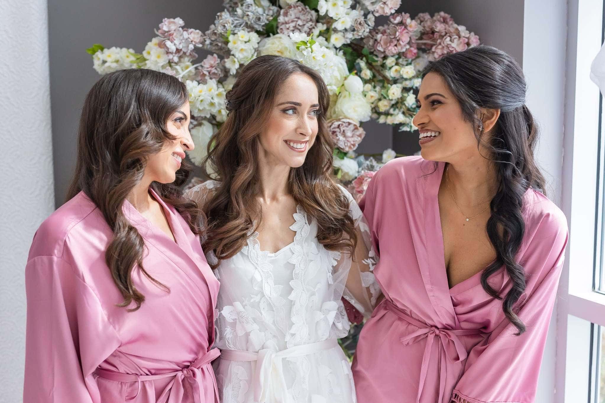 Bride and bridesmaids in pink robes before Beverly Hills wedding celebration