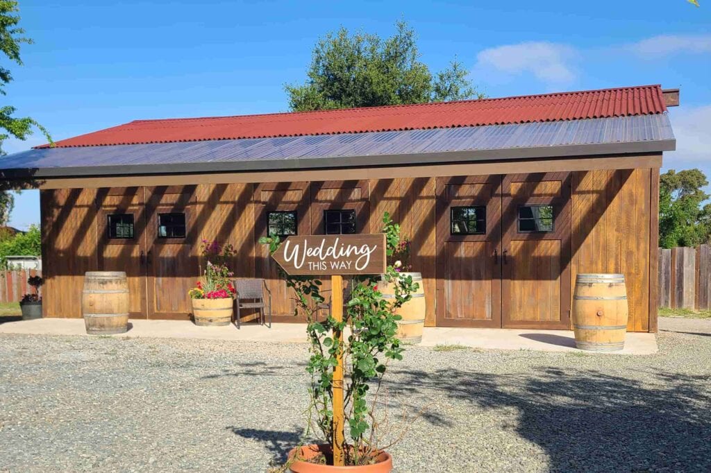 Rustic wooden Colorado wedding venue with sign pointing to ceremony