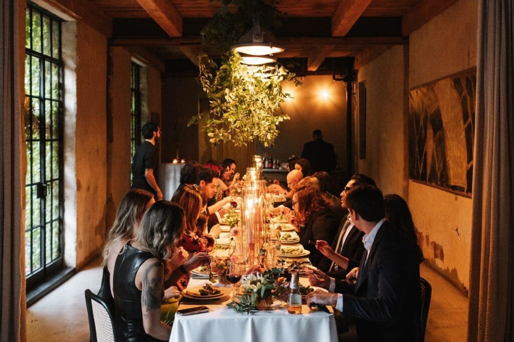 Guests enjoying dinner at rustic indoor Colorado wedding reception venue