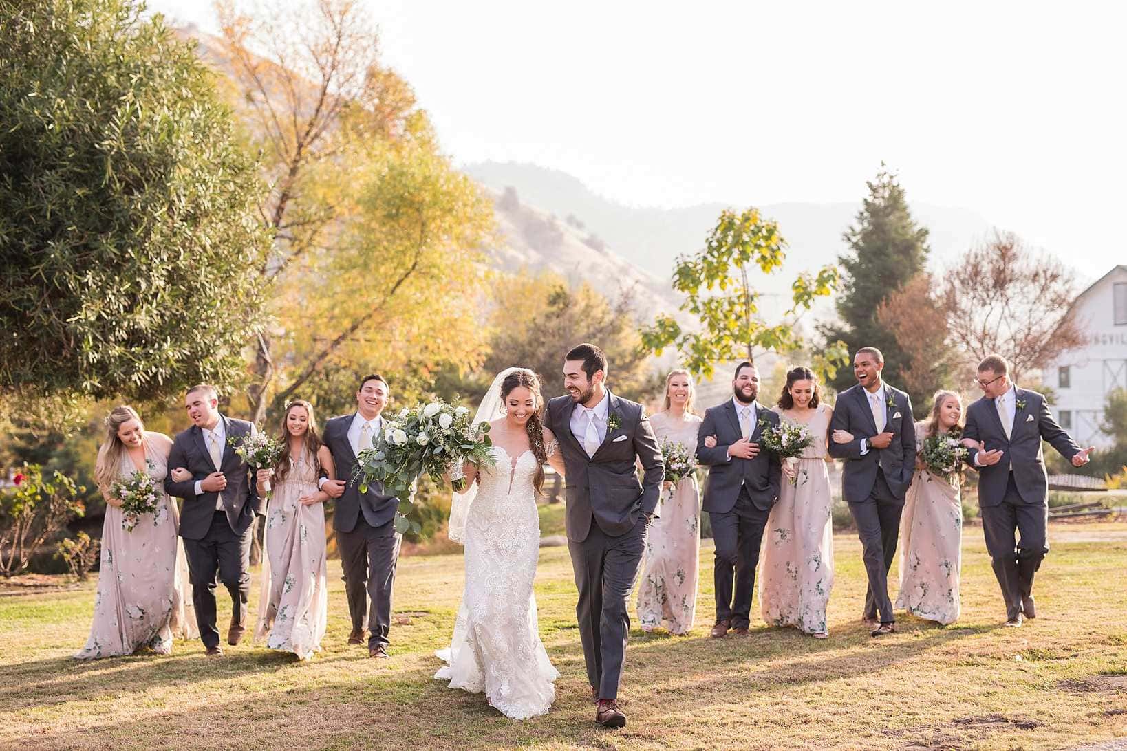 Idaho wedding party walking through autumn hills with bridal bouquets