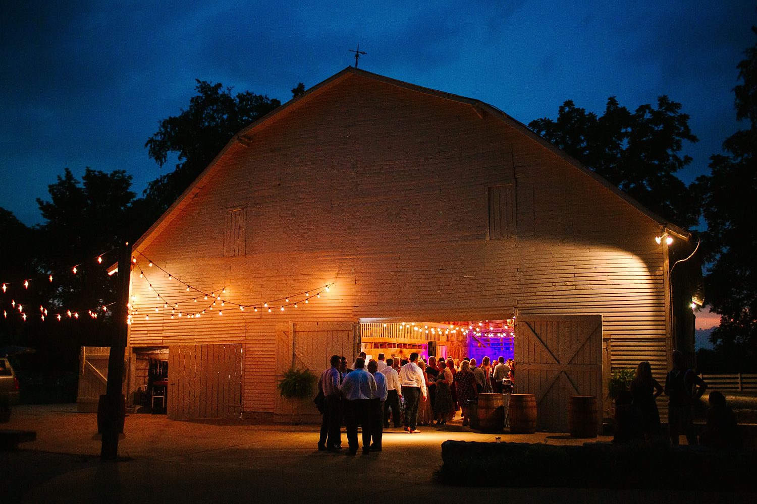 Kentucky rustic chapel venue glowing at dusk with wedding guests
