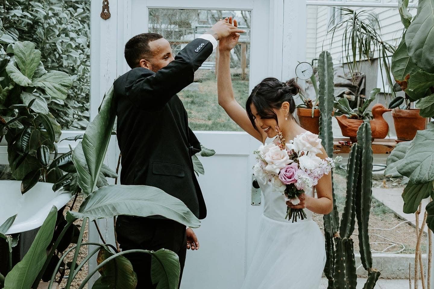 Joyful couple celebrating in a lush greenhouse venue styled by Maryland planners