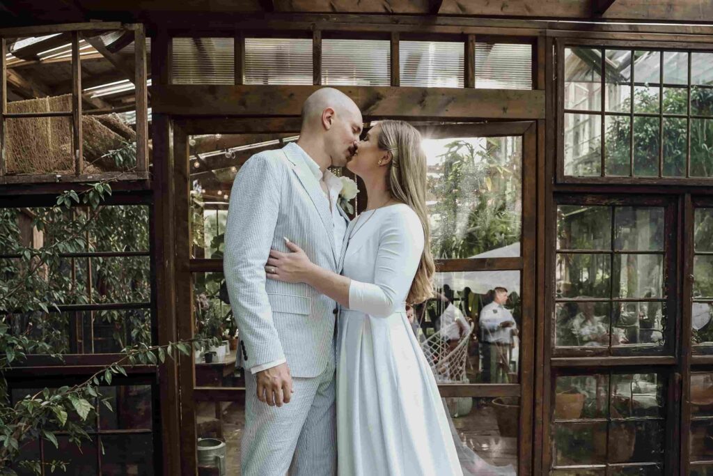 Couple embracing in a rustic greenhouse venue for a Michigan wedding