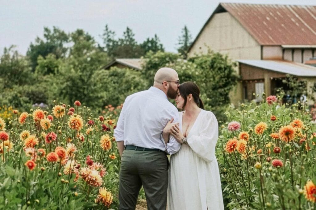 Couple embracing in a lush flower garden at an outdoor Michigan wedding