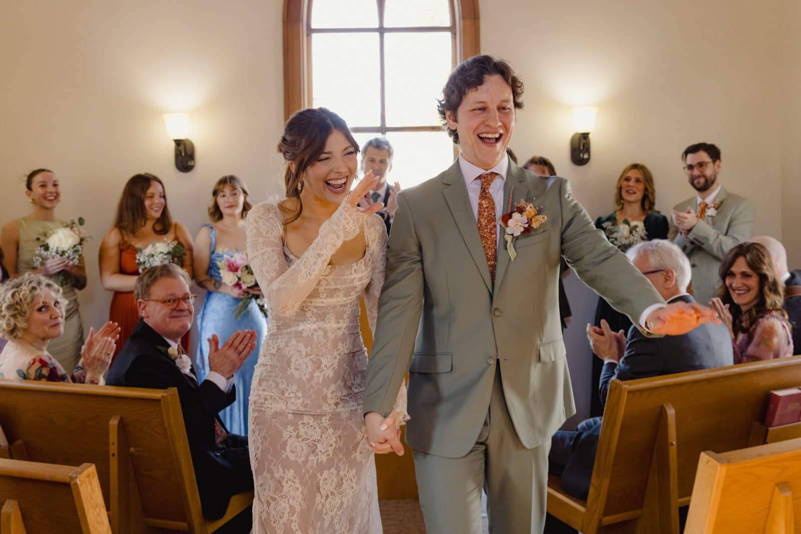 Joyful bride and groom walking down chapel aisle in Missouri