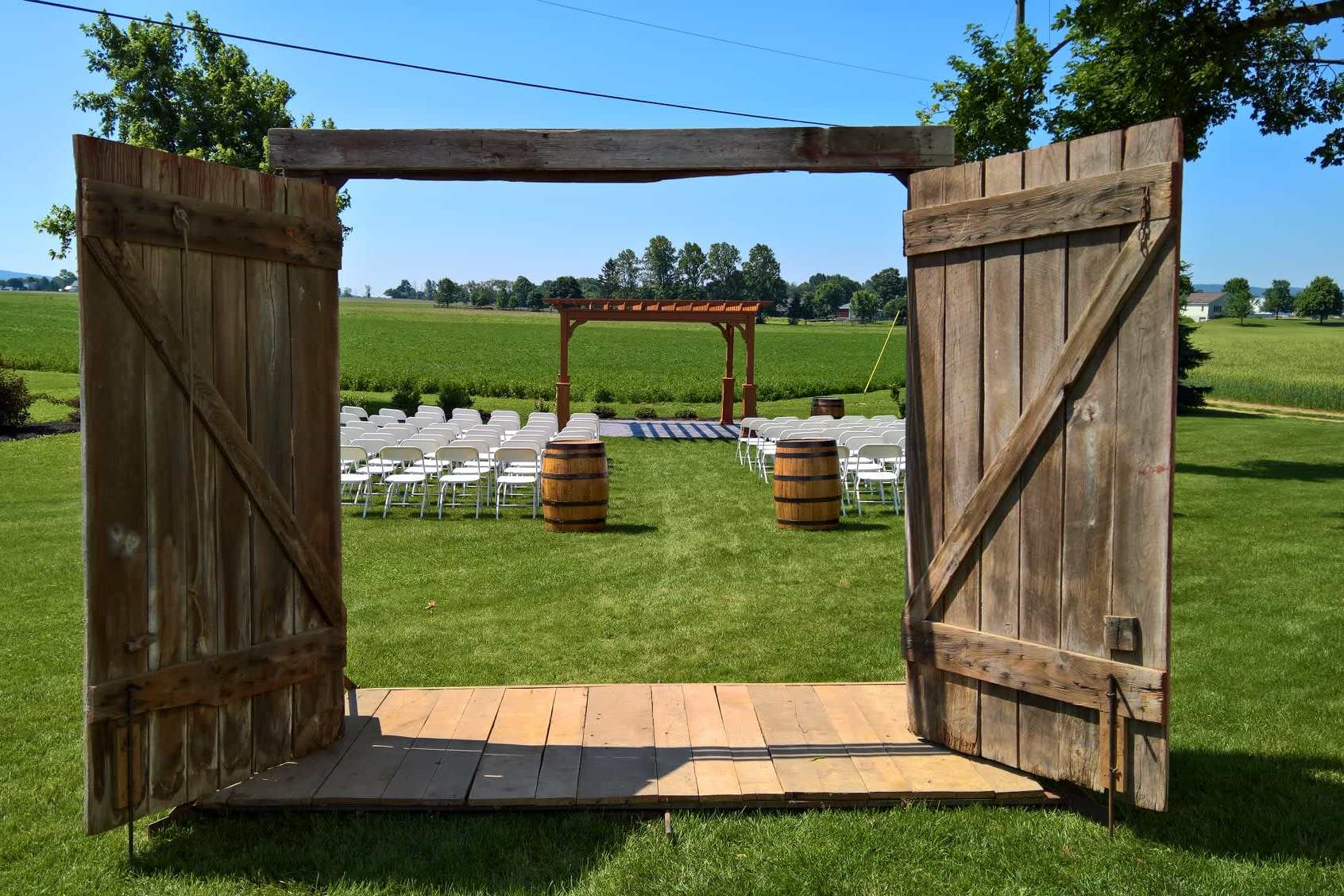 Rustic outdoor ceremony setup framed by barn doors in Pennsylvania