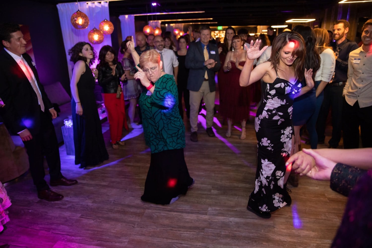 Guests dancing at a formal Reno wedding reception with purple lighting