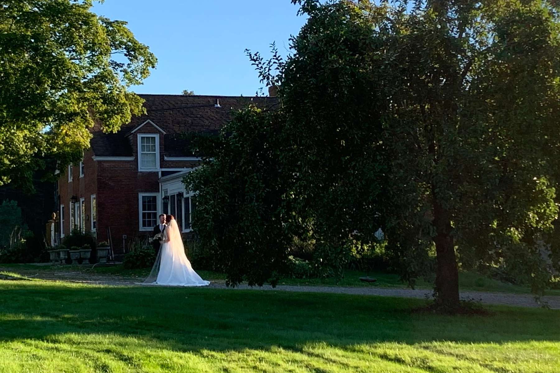 Bride on manicured lawn at classic New England property in Rhode Island