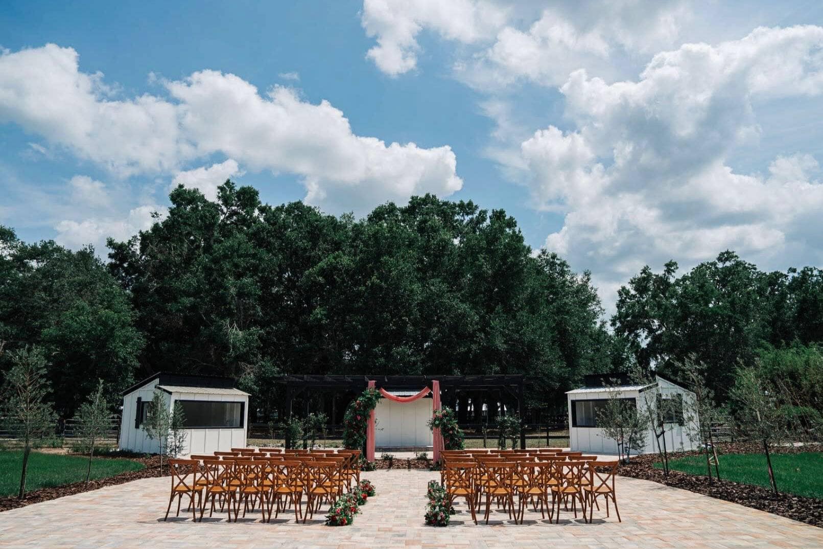 Outdoor South Carolina wedding ceremony setup with wooden chairs and central arch