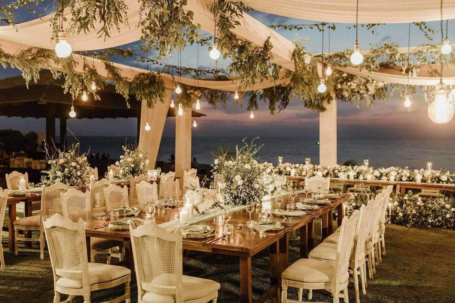 Elegant twilight waterfront wedding reception setup in South Carolina with hanging lights