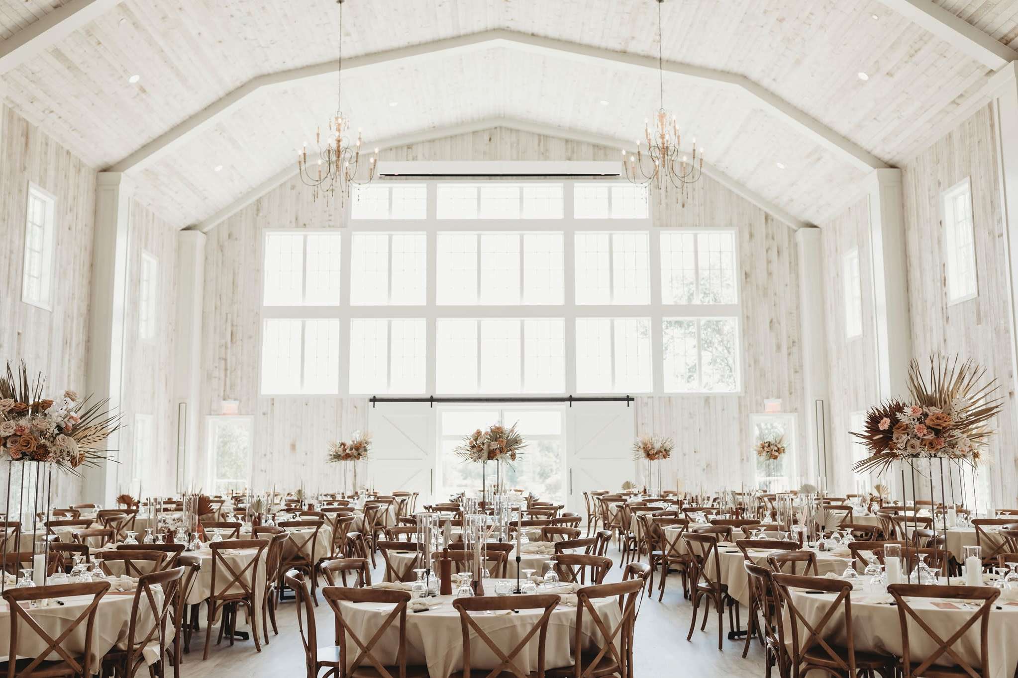 Bright indoor Wisconsin wedding reception hall with pampas grass decor