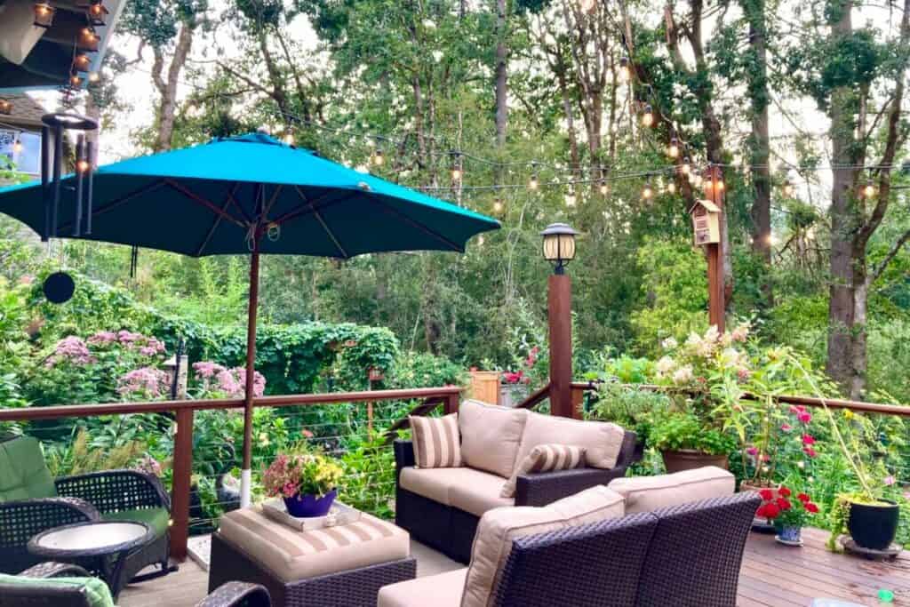 an outdoor patio surrounded by flowers and plants