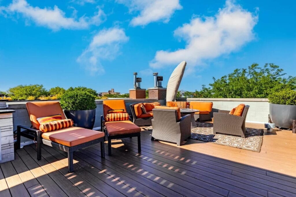 Loungers and a seating area on a roof deck on a sunny Chicago rooftop