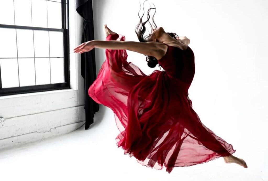 a woman in a red dress leaping