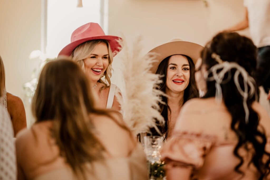 Women laugh while gathered at a table at a bohemian-inspired event