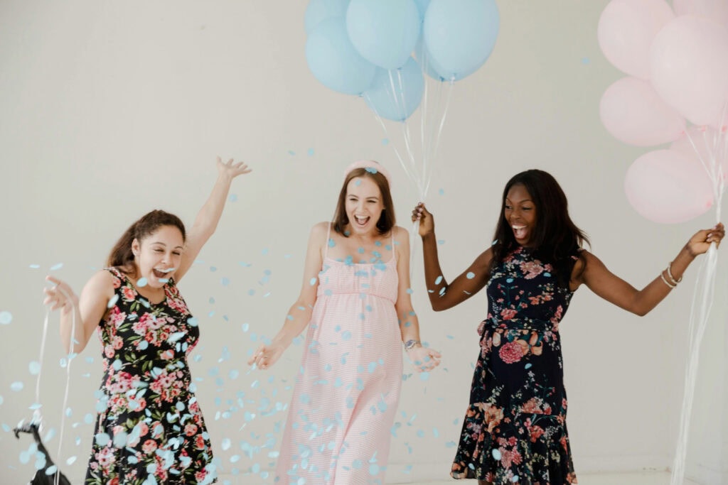Women celebrate gender reveal with balloons and confetti