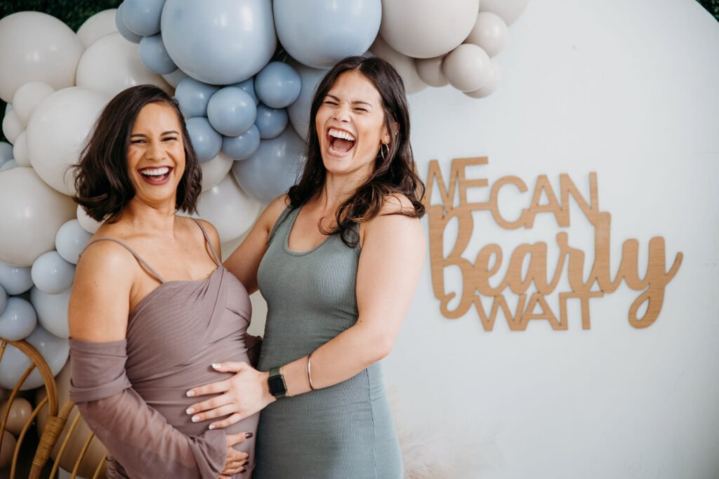 women laughing at a bear-themed gender reveal