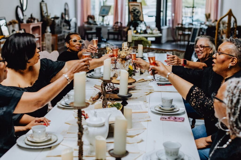 A table full of women raise champagne glasses in a toast