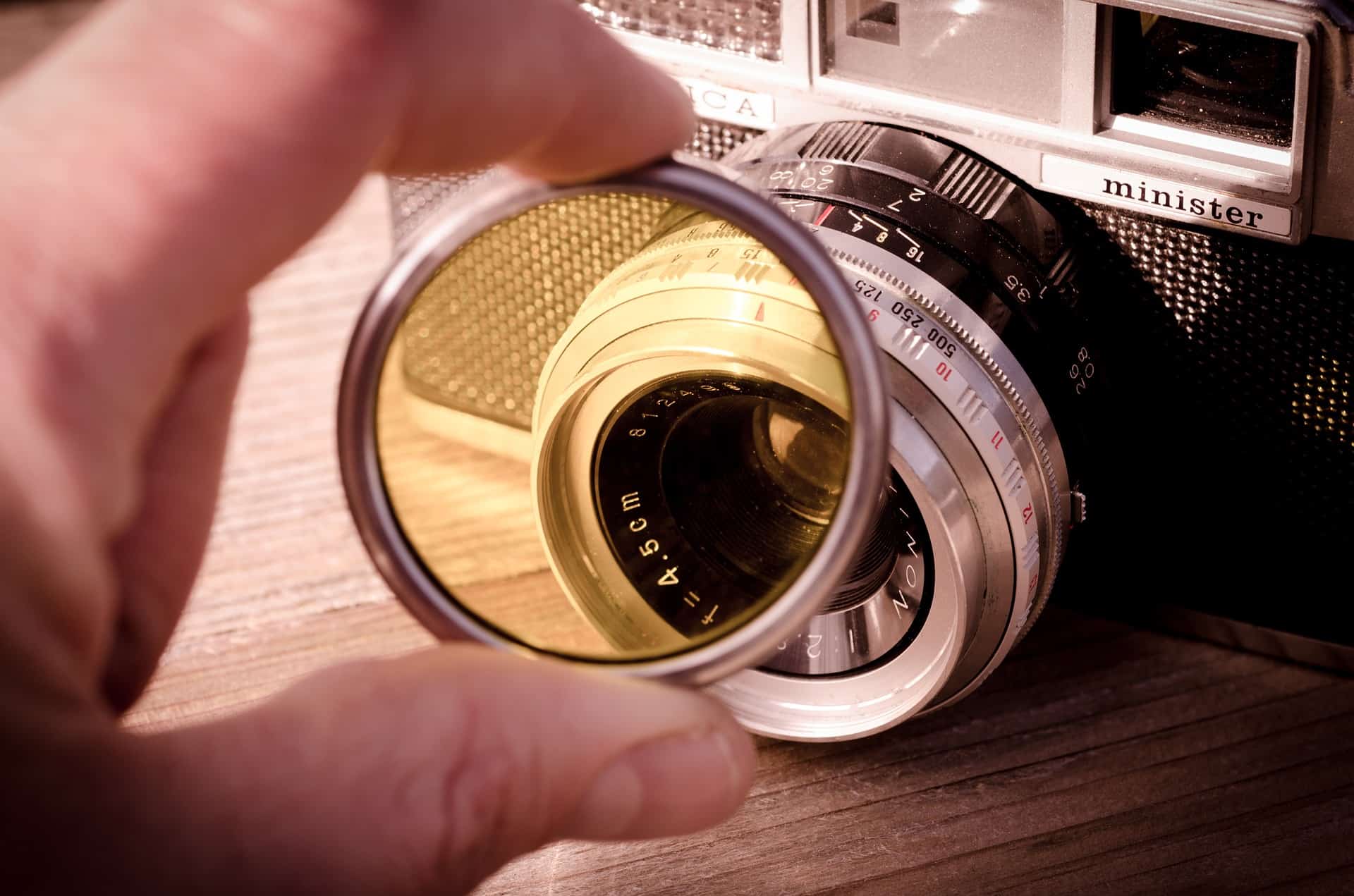 hand holding camera filter in front of dslr