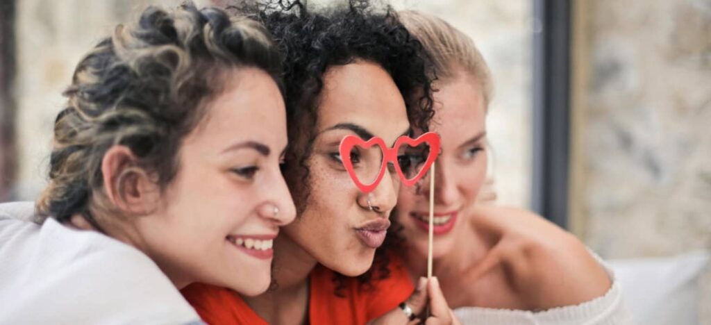 friends posing for a photo with fun heart shaped glasses