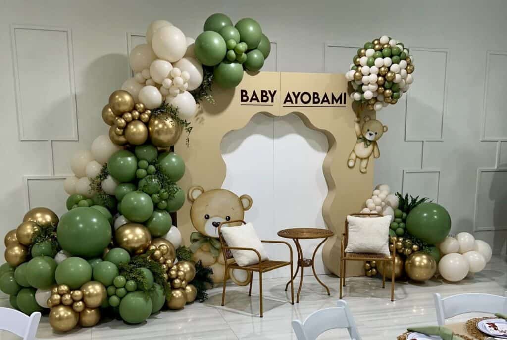 gender reveal display with green and gold balloons