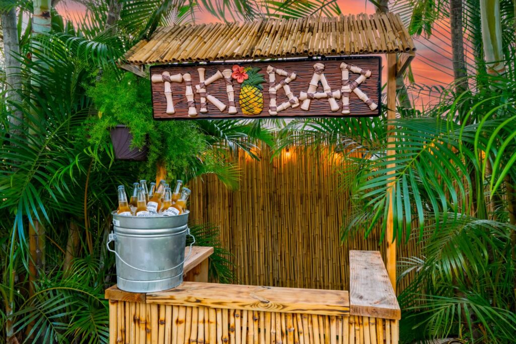 a tiki bar sign surrounded by palm trees