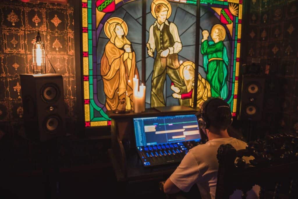 Creative music studio with stained-glass backdrop and digital workstation.