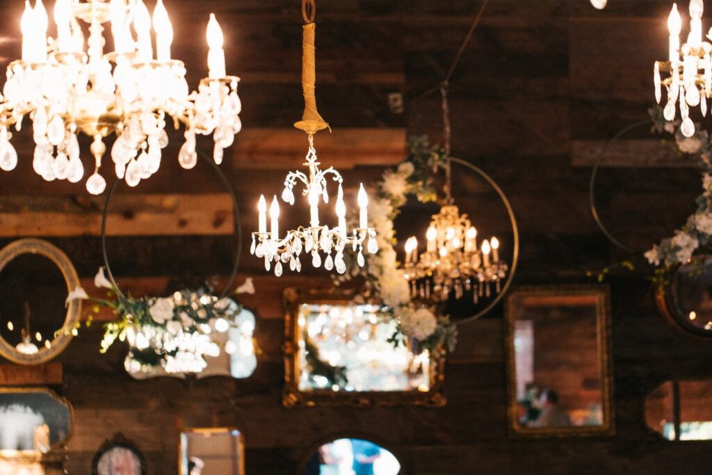 Chandeliers, mirrors, and floral decor create a romantic atmosphere at this elegant wedding reception venue.