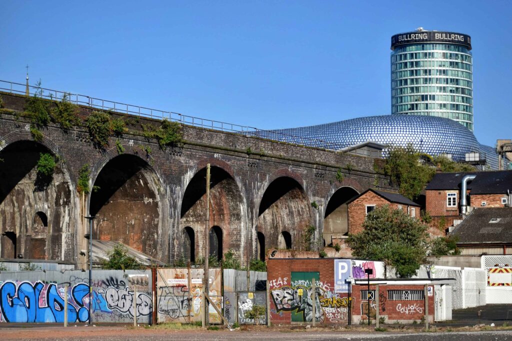 View of a train bridge in Birmingham with the Bullring tower in the background