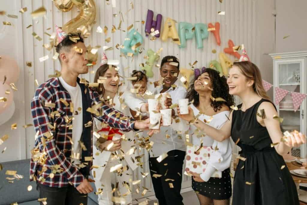 friends celebrating and toasting under glitter shower