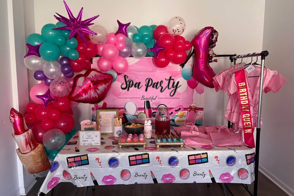 Themed birthday "spa party" with a table featuring robes, balloons, and beauty utensils