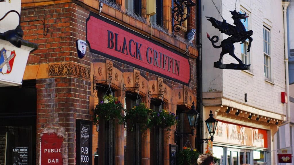 The brick exterior of a traditional British pub called 'Black Griffin'.