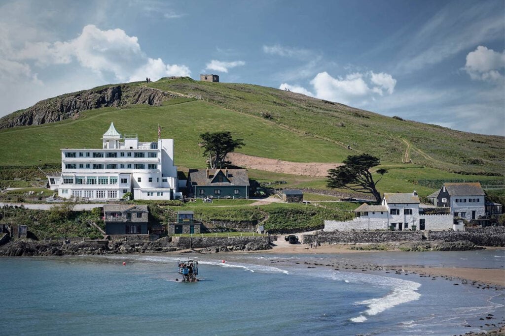 Balise alt	Sea tractor crossing the water below Burgh Island Hotel on the Devon coast