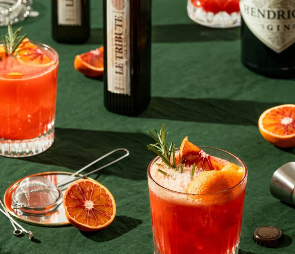 table with orange cocktails and ingredients