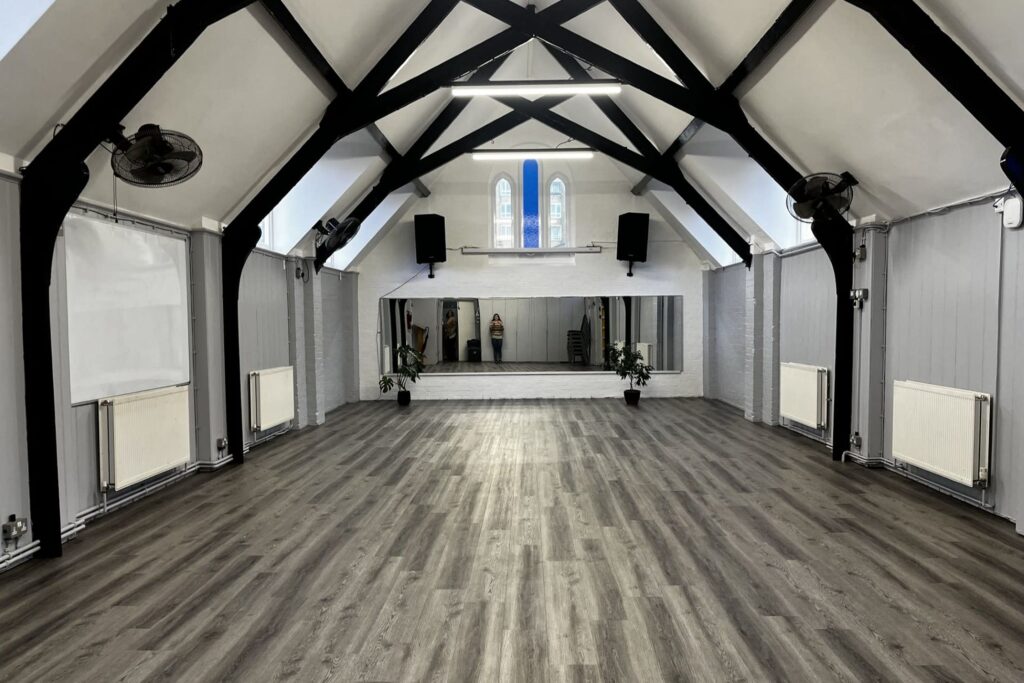 Converted church hall with vaulted ceilings and a stage