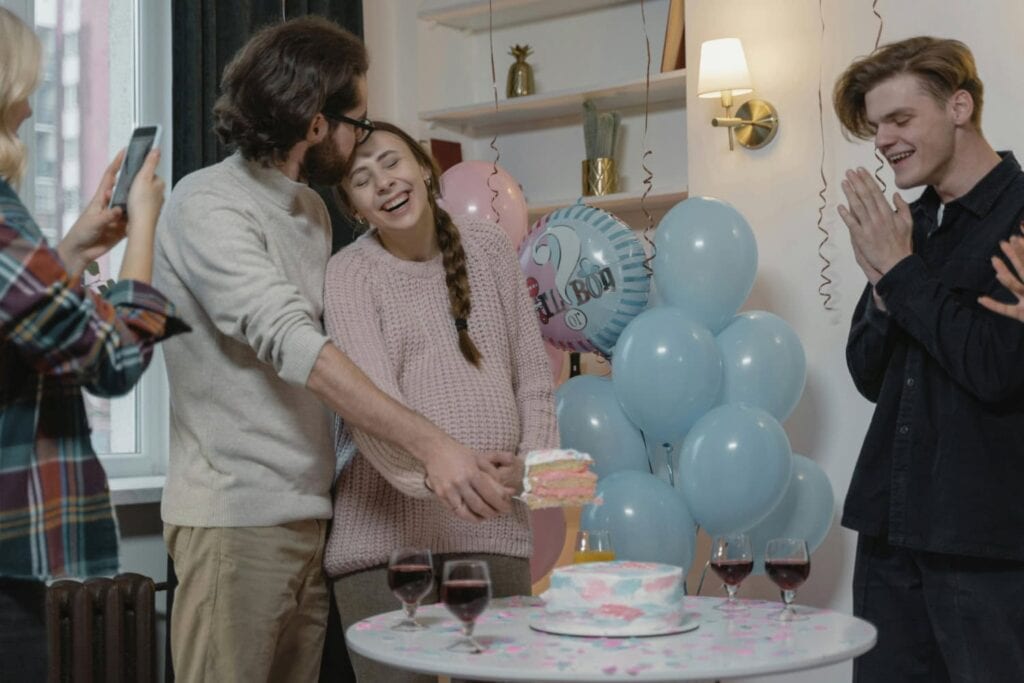 couple cutting a gender reveal cake
