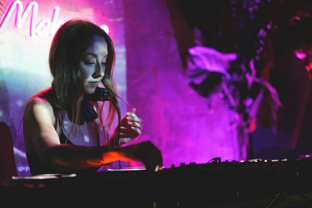 A female DJ playing music at a party.